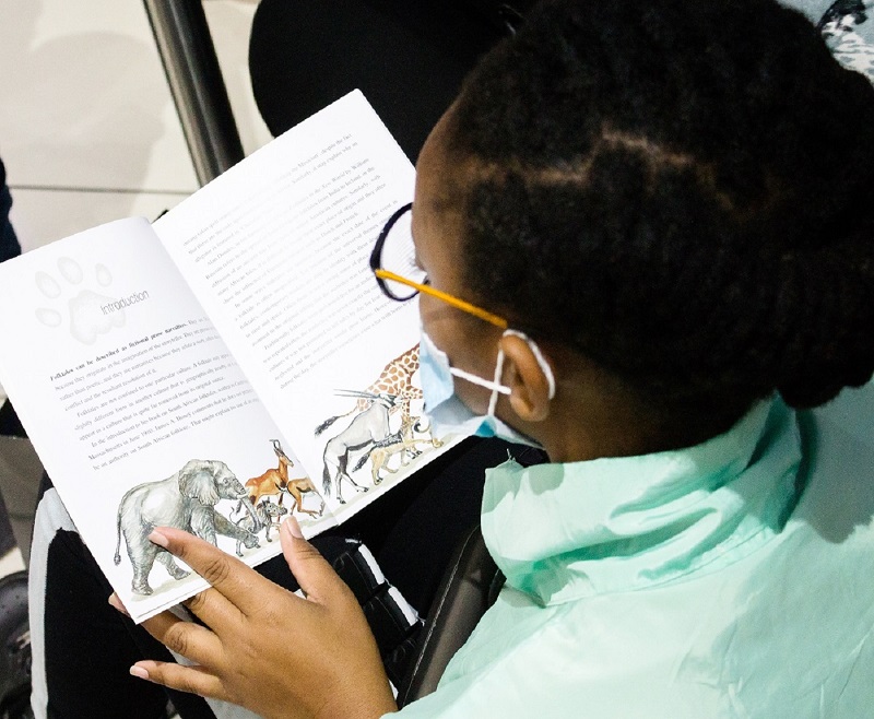 Terlisha Potgieter (14) wearing her brand-new spectacles, caught reading a new book, kindly donated by Bargain Books.